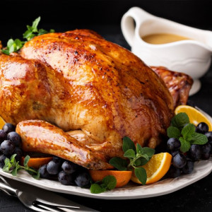 Roasted whole chicken garnished with fruits and gravy, a famous American cuisine.