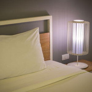 Topside of the bed with a bedside lamp in a budget hotel room