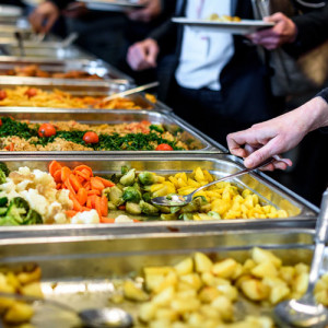Casseroles filled with variety of food, lined in a buffet table for a food catering service.