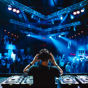 DJ on headphones playing music for the crowd in a nightclub
