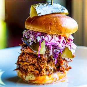 Pulled pork sandwich with cabbage topped with pickles is a sample of comfort food in Las Vegas.