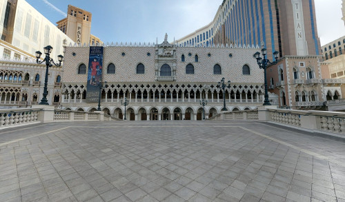 Italian inspired architecture of The Venetian - a 5 star luxury hotel resort in Las Vegas, showing a wide, concrete walkway towards its entrance