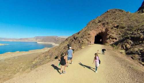 Las Vegas A woman & a young boy walking along a smooth, hiking trail that stretches through one of the tunnels of the Historic Railroad in Boulder City, NV