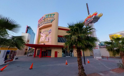 Side view of Tex Mex Tequila Bar & Grill - a Mexican restaurant in Las Vegas, with small palm trees aligned at side of the pavement