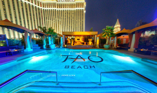 Wide & clear swimming pool of Tao Beach club, pool party venue in Vegas, facing a luxury cabana at night time