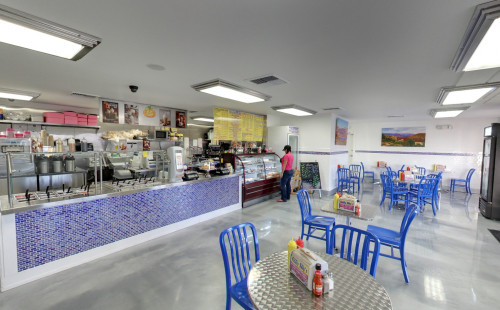 Clean & brightly lit interiors of Chilly Jilly'z cafe & bakery in Boulder City, NV with dining tables, chairs & food counters filled with breads, sandwiches & desserts like ice cream, shaved ice & frozen yogurts
