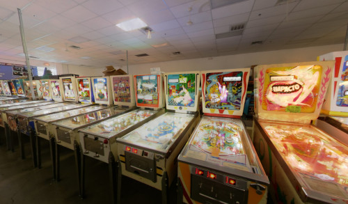 Row of several, colorful, vintage pinball machines with different themes inside Pinball Hall of Fame, a famous pinball machine museum in Nevada.