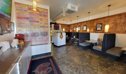 A huge poster of the menu posted on the wall beside the utensils counter that faces the dining area inside Rollin Smoke Barbeque restaurant in Las Vegas
