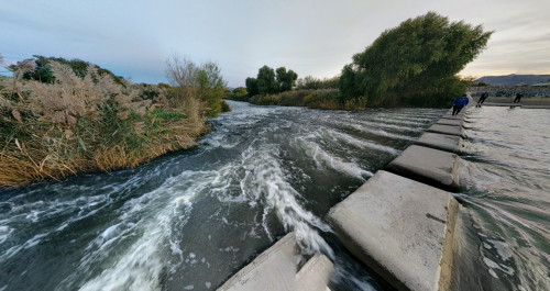 A concrete pathway over the rushing waters of the river in Clark County Wetlands Park, Las Vegas