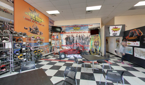 undefined Receivng area with a copule of chairs & tables & a metal rack on the left side full of helmets inside SunBuggy Fun Rentals - tour operator in Vegas with ATV & dune buggy car rentals