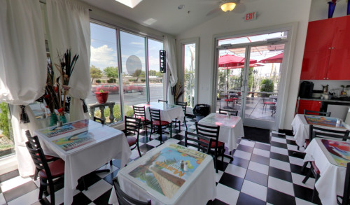 Las Vegas Dining area with a view of the patio at Yassou Greek Grill Cafe - a Greek restaurant in Vegas with black & white checkered tiled flooring & cool ambiance