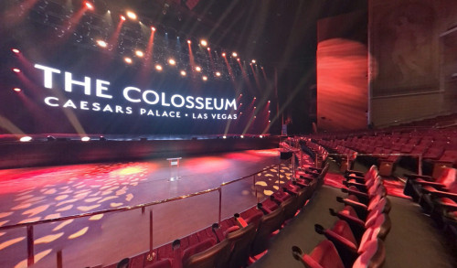 Rows of multiple theater chairs facing the stage with spotlights inside The Colosseum at Caesars Palace, Las Vegas