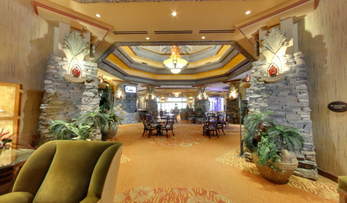 The capacious lobby of Bali Hai Golf Club in Las Vegas decorated with big pots of plants & a chandelier at the center of Function Hall.
