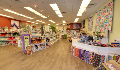 Inside Quiltique - a fabric store in Las Vegas, NV are dozens of colorful patterned fabrics together with other quilting & sewing materials