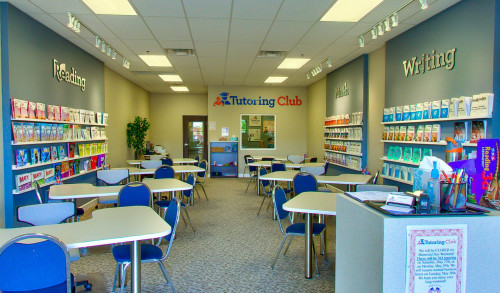 Sets of study tables & chairs with reading materials displayed on the wall inside Tutoring Club - Decatur Blvd. Las Vegas
