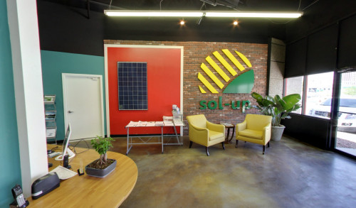 The office of Sol-Up USA in Las Vegas showing the lobby with single-seater couches & a sample display of a solar panel