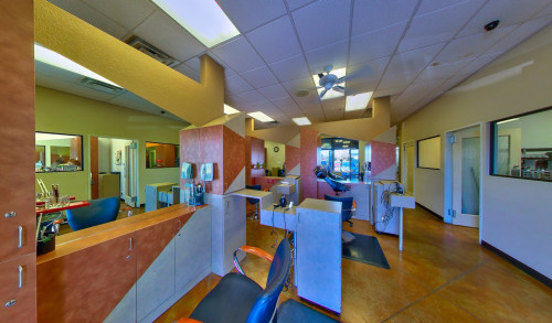A hairdresser's working station with huge mirrors, salon chairs & cabinets inside Tim Vigil @ Scandals Salon and Day Spa in Nevada