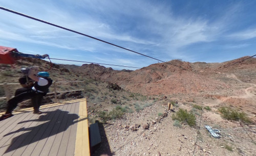 A tourist wearing safety vest, helmet & full body harness is about to take off on a zipline adventure in Flightlinez Bootleg Canyon, an outdoor tourist attraction in Boulder City, NV