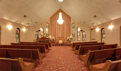 Las Vegas Wooden benches along a carpeted aisle & a piano on the altar in one of the chapels of Vegas Weddings